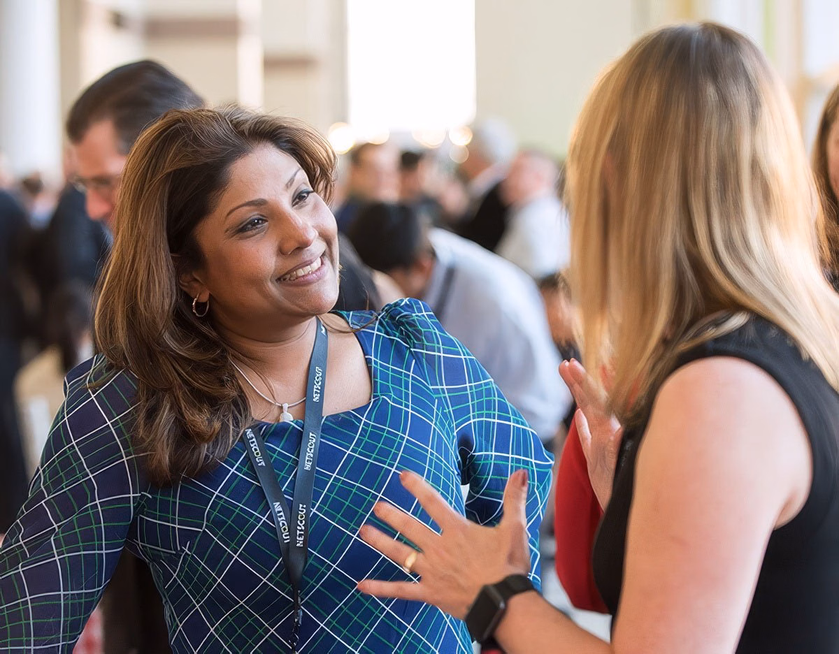Two women engaged in conversation at a corporate event in Boston.