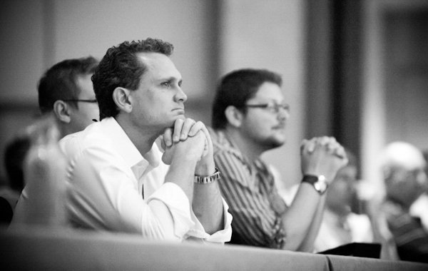Two men attentively watching a corporate event in Boston.