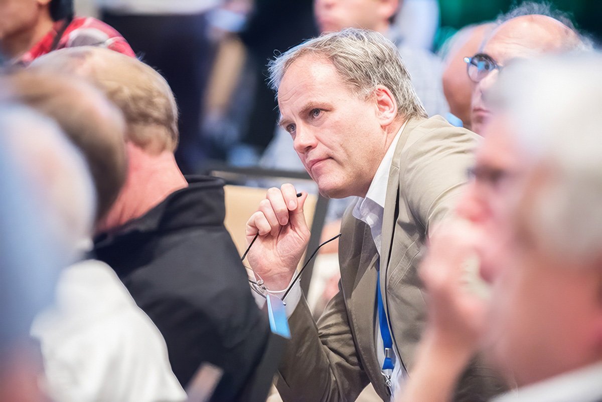 Businessman listening attentively during a corporate event in Boston.