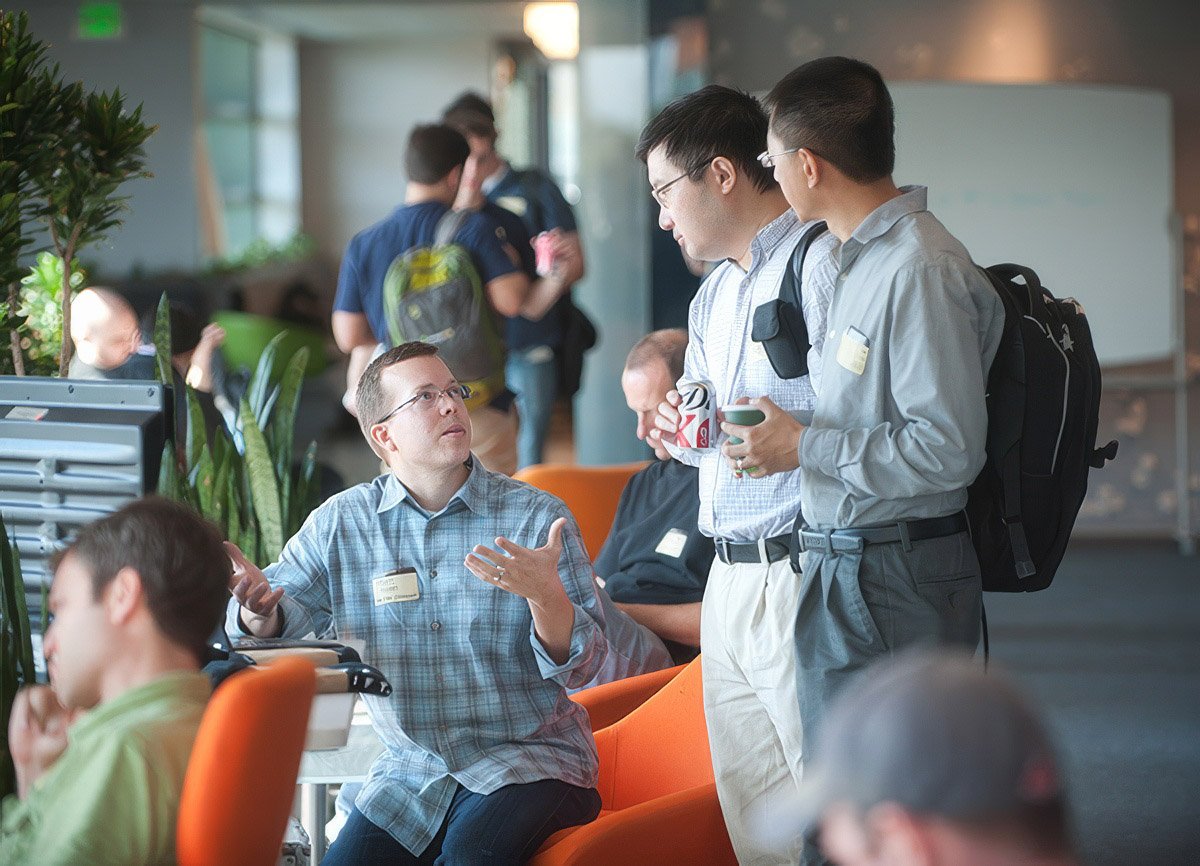 Three Boston conference attendees engaged in conversation