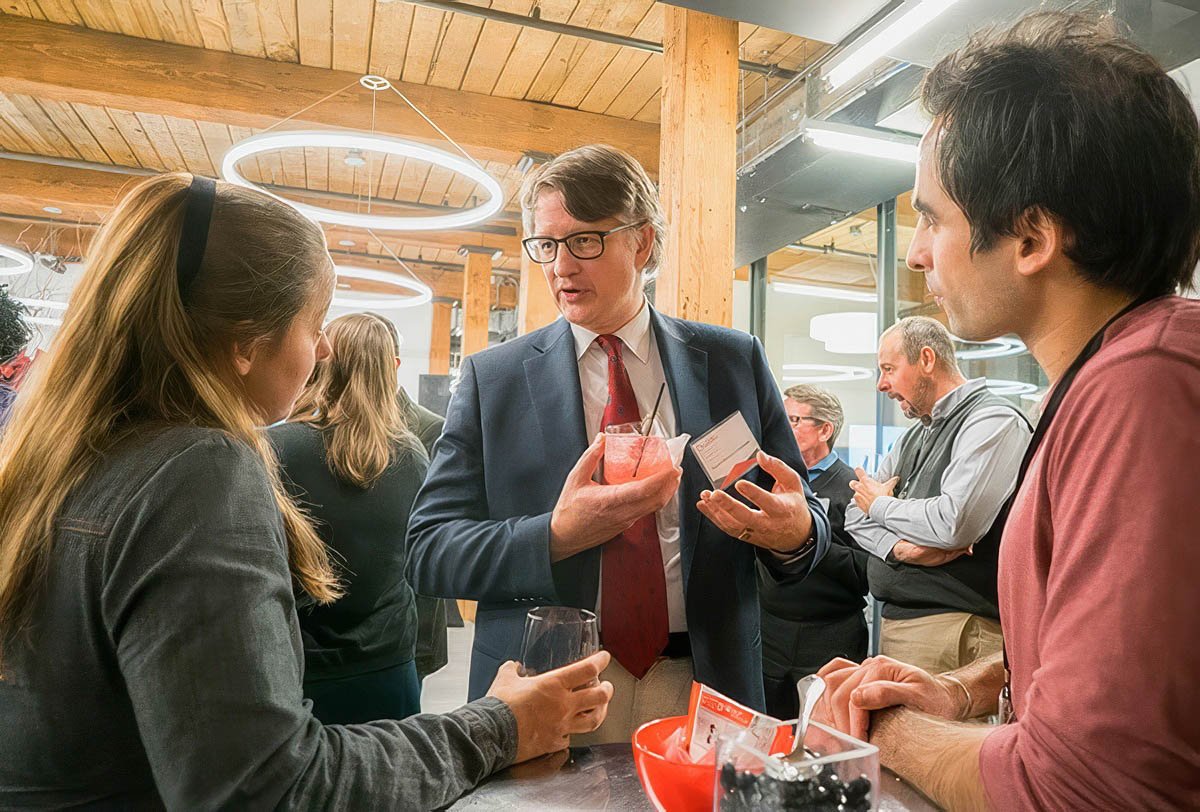 Conference attendees engaging in conversation at a networking event in Boston.