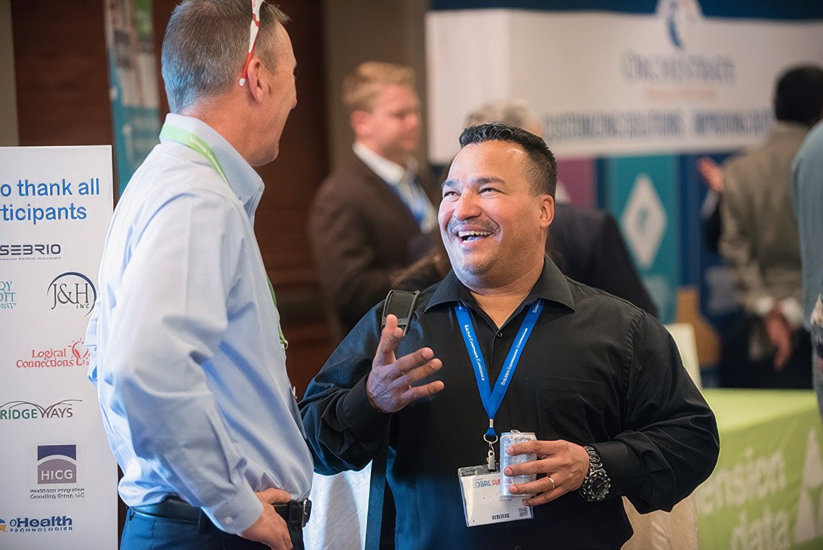 Two men are engaged in conversation at a conference in Boston.