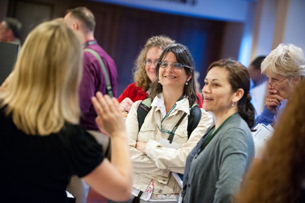 Group of smiling women engaging in conversation at a corporate event in Boston.
