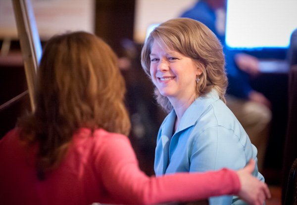 Two women smiling and engaging in conversation at a corporate event in Boston.