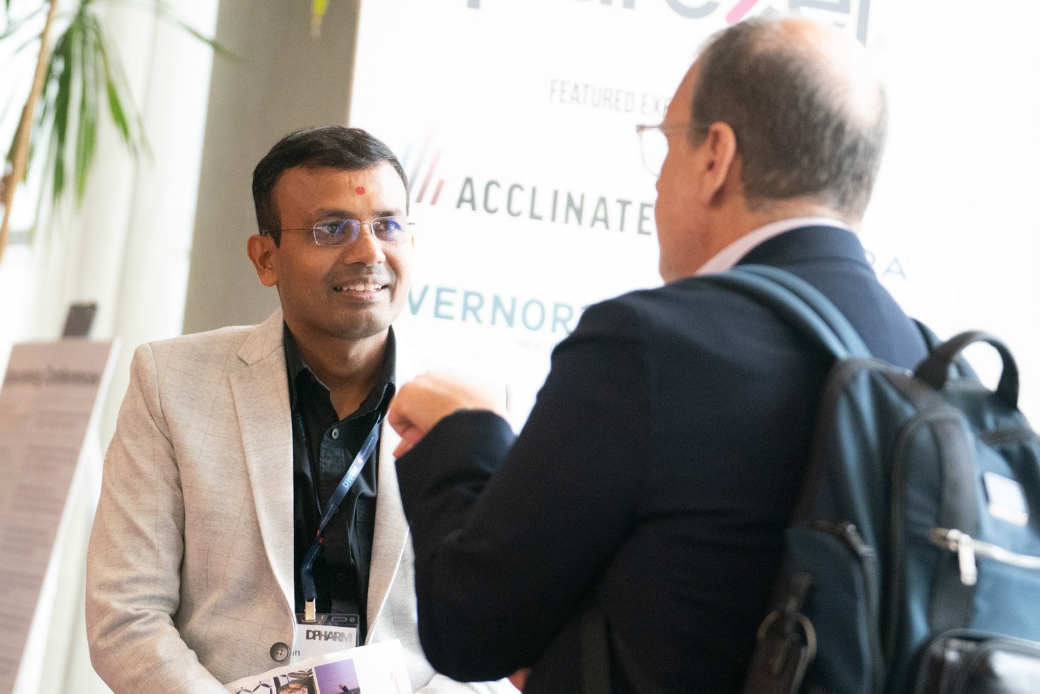 Two professionals engage in conversation at a corporate event in Boston.