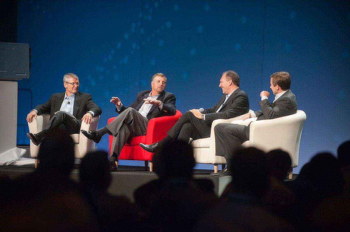 Four speakers engaged in discussion during a panel at a Cambridge business conference.