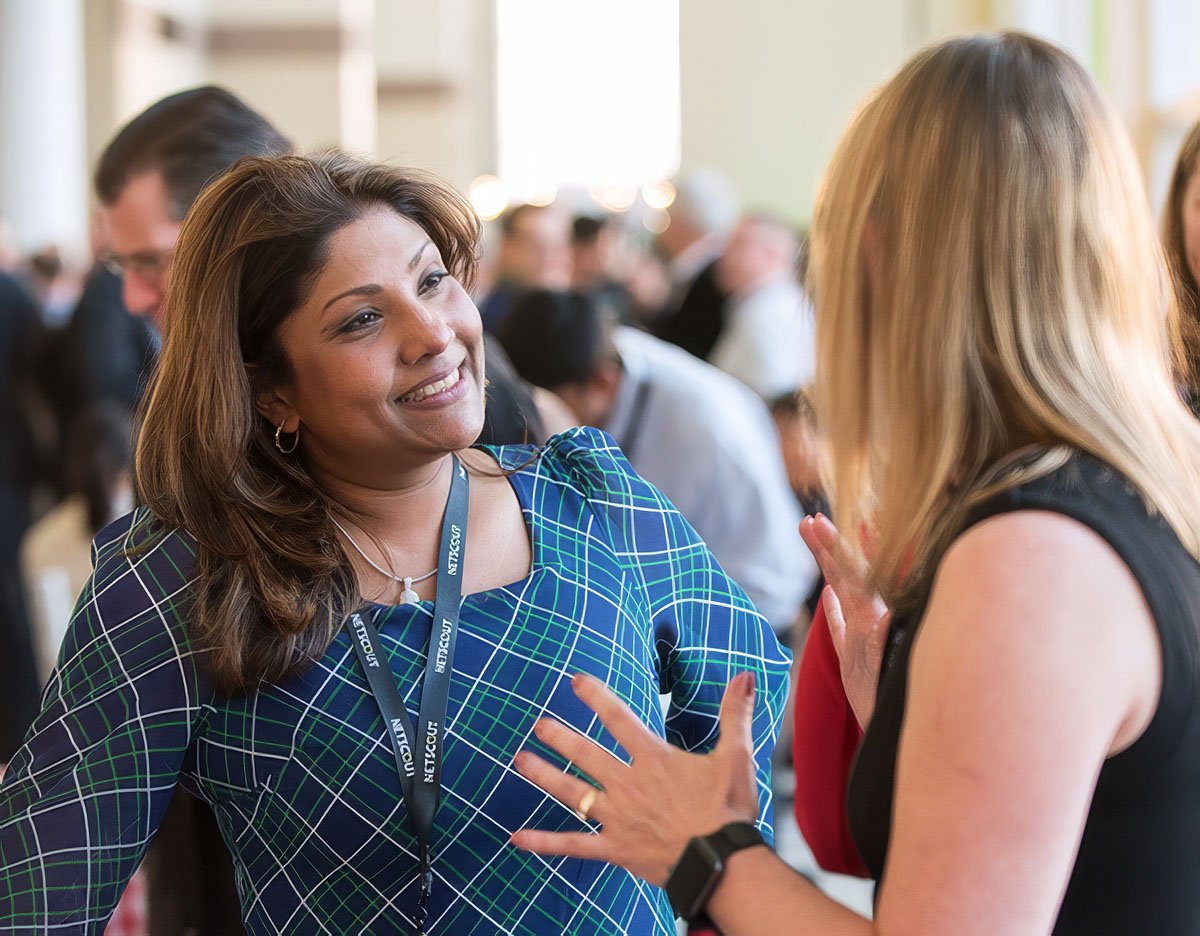 Two women engaged in conversation at a corporate event in Boston.